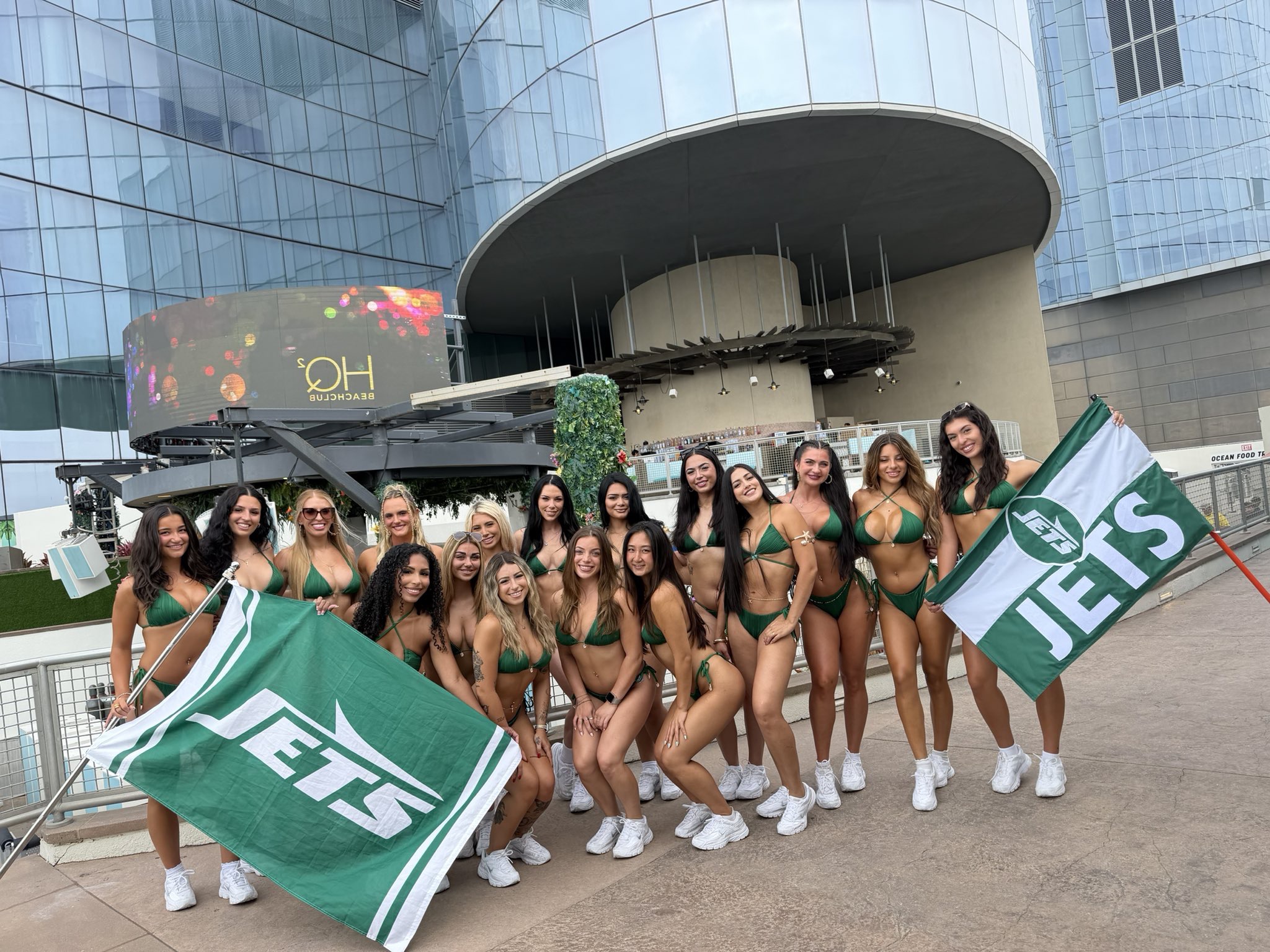 Jets fans in green swimwear holding Jets flags outside HQ2 Beachclub in Atlantic City
